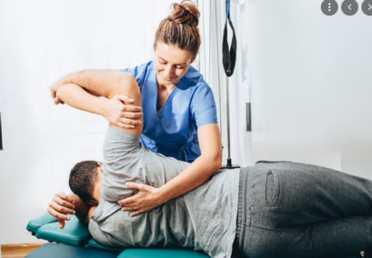 Physiotherapy nurse helping a patient move their back and arm